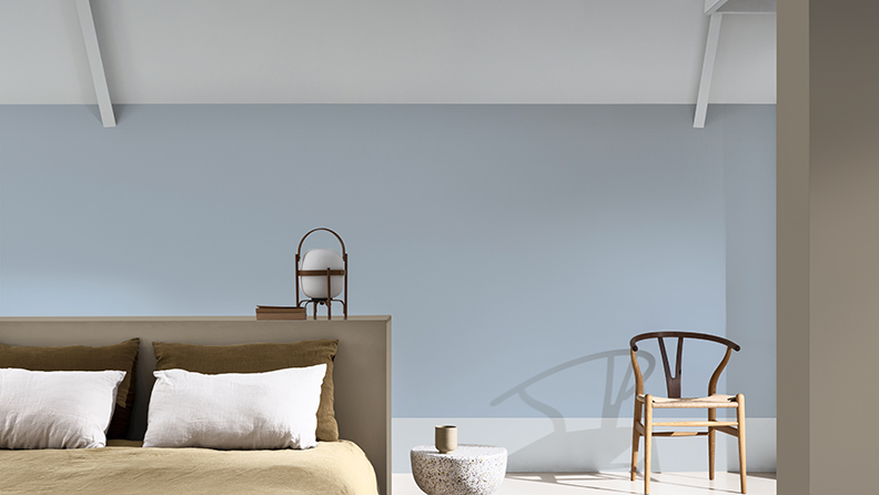 Schlafzimmer mit blauer Wand und schräger Decke